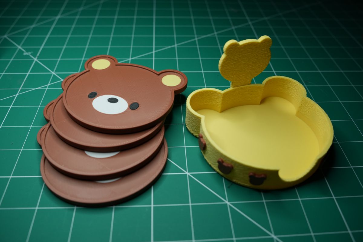 Four bear coasters stacked beside the empty fuzzy holder