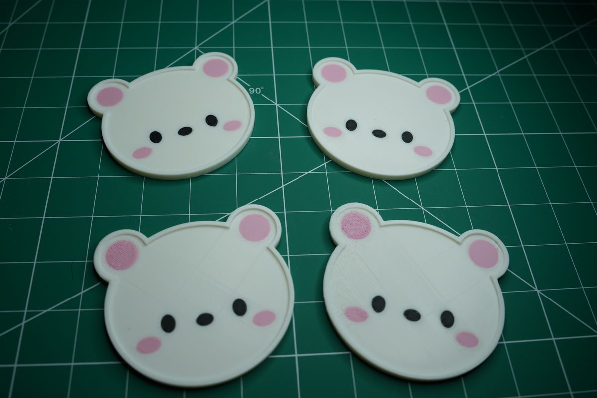 Four white bear coasters laid out on the cutting mat, pink ears and cheeks