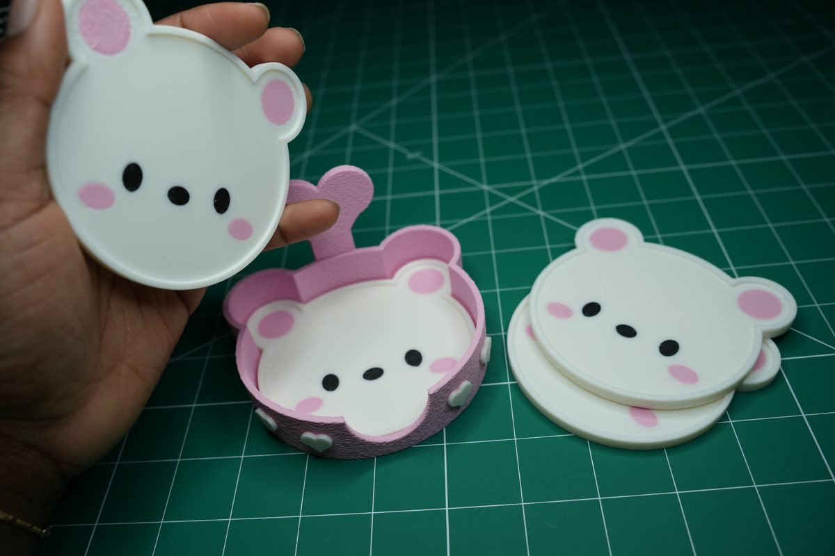 A hand lifting a coaster out of the holder by its finger notch